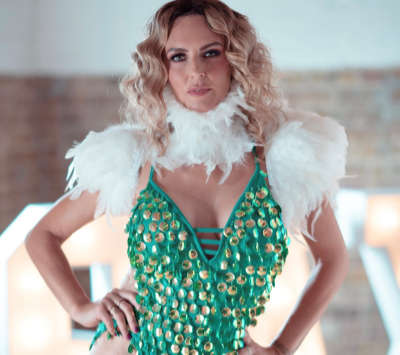 Kay with green costume with white feathers