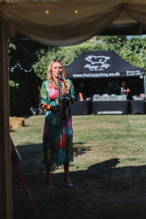 Kay and Lauren stood on dancefloor holding sax at Lauren and Jamie's wedding