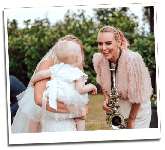 Kay laughing with a bride and baby