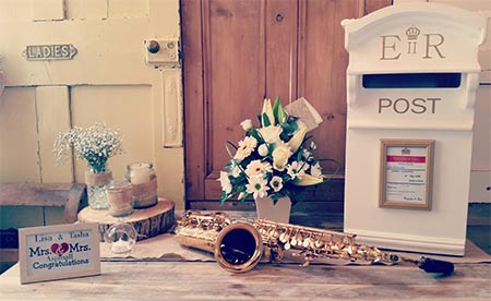 Wedding photo with happy couple plaque flowers, sax and e.r. post box