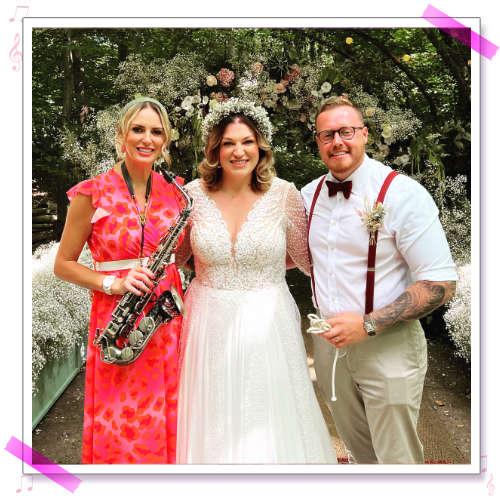 Kay stood with Amy and Chris infront of a floral display at  their wedding