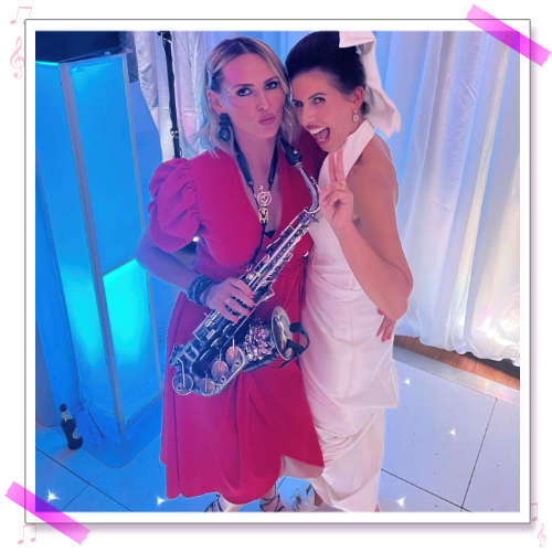 Kay and Lauren stood on dancefloor holding sax at Lauren and Jamie's wedding
